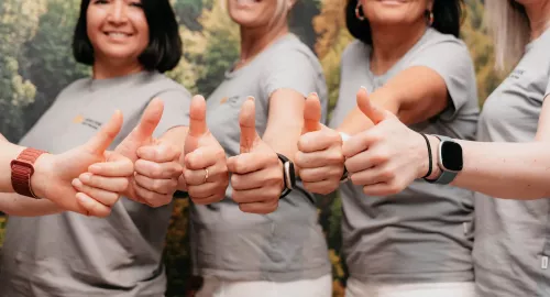 Mitarbeiterinnen zeigen ihren Daumen nach oben